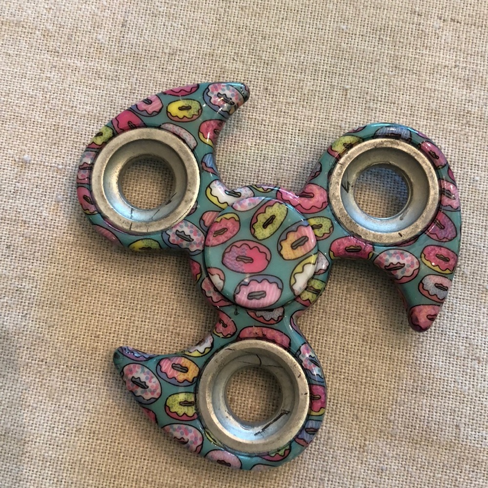 Fidget spinner with donuts printed on it.